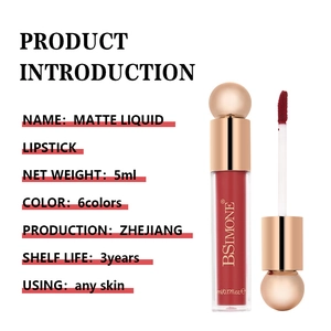Macro detail of matte liquid lipstick in dark brick red with a gold spherical cap