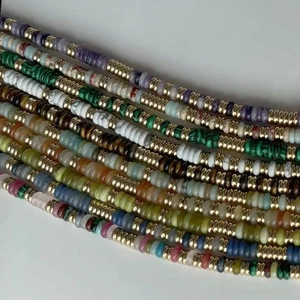 Détail de colliers en pierres fines colorées avec intercalaires en disque doré