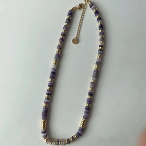 Détail du collier de perles violettes avec perles dorées et fermoir mousqueton
