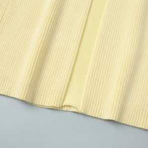 Close-up of pale yellow knit vest showing fine ribbed texture and detailed stitching