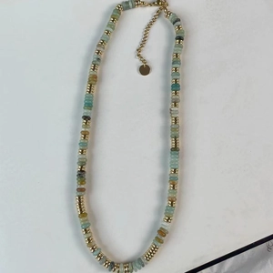 Détail de perles en pierres naturelles et séparateurs dorés sur un collier multicolore