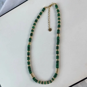 Détail du collier en malachite verte avec perles dorées et fermoir mousqueton