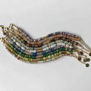 Détail de colliers en perles de disque colorées avec intercalaires dorés et fermoir
