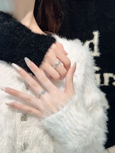 Close-up of couple's silver rings featuring blue heart stone and hammered texture design