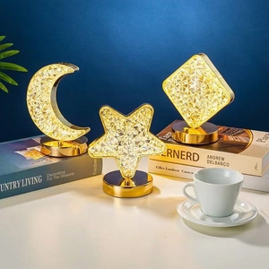 Detailed view of crystal-style LED star and moon lamps with gold bases on books