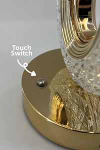 Detail of touch switch on golden plated base with diamond cut crystal lampshade