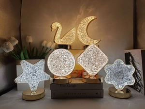 Artistic crystal night lights with golden metal bases in moon, star, and swan shapes