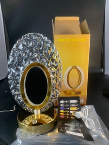 Detail view of oval crystal night light with polished gold base and USB charging cord