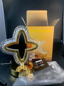 Star-shaped acrylic night light with gold trim and USB charging cable on retail packaging