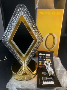 Close-up of diamond-cut crystal desk lamp with USB cable and color control manual