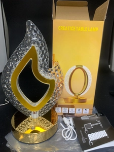 Unboxing detail of prism flame table lamp with gold base, USB cable and manual