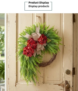 Detail of red hydrangea wreath with lush fern leaves and burlap bow on vintage door