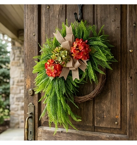 Close-up of farmhouse hydrangea wreath with greenery and burlap bow on a wooden door