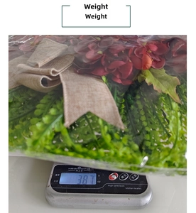 Detailed view of artificial hydrangea wreath on a digital scale showing 387g weight