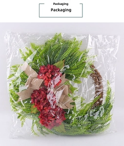 Artficial hydrangea wreath with burlap bow shown in clear protective packaging