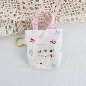 Détail de la mini pochette fleurie avec poignée à carreaux roses et mousqueton jaune