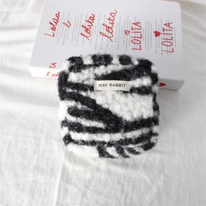 Close-up of zebra pattern plush storage bag with MAY RABBIT woven label detail
