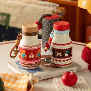 Detail shot of cute cartoon insulated thermal cups with a handy carrying strap and bag