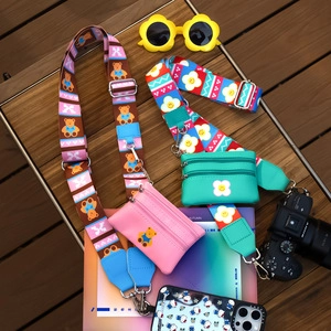 Detailed set of adjustable cartoon wide straps and mini PU zip pouches on a wooden deck