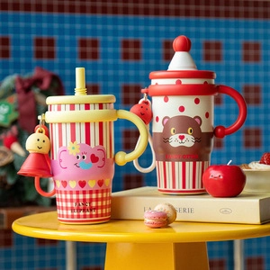Close-up of cute cartoon elephant and otter patterned thermal insulation cups on a yellow table