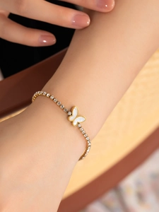 Gros plan d'un bracelet papillon doré avec incrustation de nacre et cristaux brillants