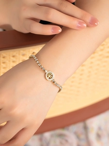 Gros plan d'un bracelet arbre de vie doré avec zircons porté au poignet d'un mannequin