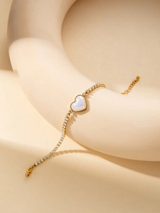 Détail du bracelet cœur doré avec centre opale et chaîne en zircone sur support