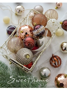 Primer plano de bolas de Navidad color champán con texturas en una cesta metálica