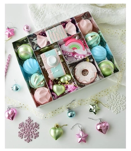 Detalle de adornos navideños macaron en caja plateada con formas de dulces y corazones