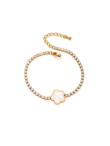 Détail d'un bracelet tennis doré orné d'une fleur blanche à cinq pétales et fermoir