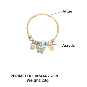 Detailed shot of golden wire bracelet featuring blue beads and butterfly charms
