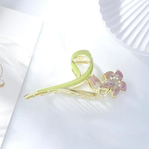 Golden flower hair claw with green enamel ribbon and purple gradient petal details