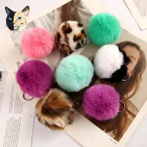 Detailed close-up of faux rabbit fur pom pom keychains in diverse colors and animal prints