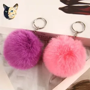 Detail of soft purple and pink faux rabbit fur pompoms with silver metal keychains