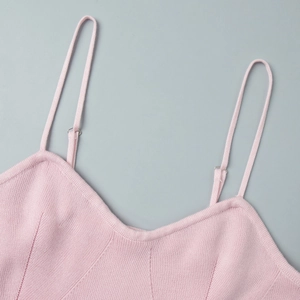 Close-up of pink knitted dress with V-neckline and adjustable silver buckle straps