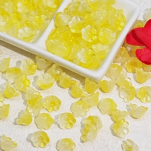 Macro detail of translucent yellow lily-of-the-valley shaped glass beads for DIY jewelry