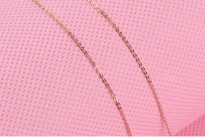 Detailed close-up of a rose gold s925 silver link chain necklace over pink mesh fabric