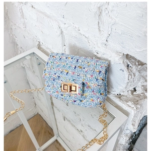 Classic tweed chain crossbody bag for girls with gold buckle on a white display rack