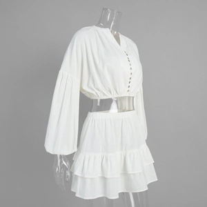 Detail of white cotton set featuring lantern sleeves and tiered cake skirt texture