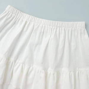 Detailed macro view of white cotton fabric layers with elastic waistband and pleated texture