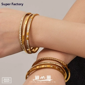 Detail of 18k gold plated bangle set with micro-pave white zircon stones on model's wrist