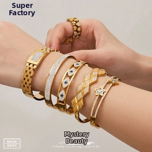 Detailed close-up of 18k gold plated bracelets and heart ring with sparkling zircons