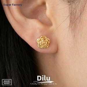 Detailed close-up of a gold rose-shaped earring with multi-layered spiral petals on ear