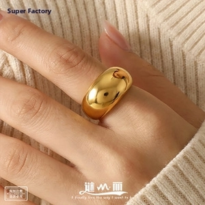 Macro shot of a chunky polished 18K gold-plated irregular hollow ring on finger
