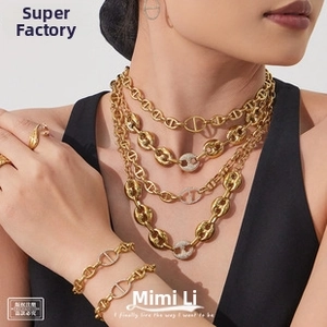Macro detail of gold plated anchor chain jewelry set with layered diamond accents