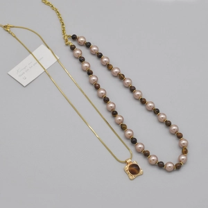 Détail du collier chaîne serpent dorée et perles avec pendentif œil de tigre