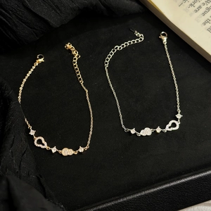 Elegant gold and silver heart bracelets with sparkling cubic zirconia on a black base