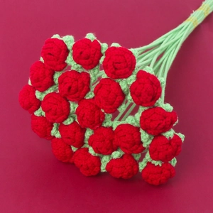 Handmade crochet bouquet featuring red knitted roses with green stems on red background
