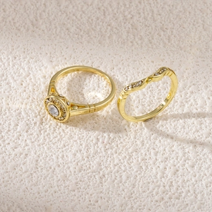 Macro shot of gold-plated wedding ring set with halo round zircon and curved diamond band