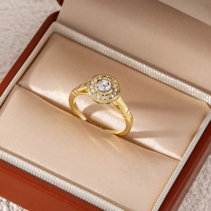 Macro detail of a gold plated engagement ring with a round center crystal in a jewelry box